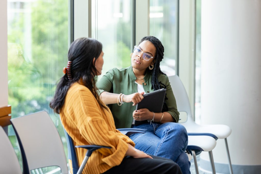 A picture of an empathetic female counselor listening to a vulnerable patient sharing a story about a difficult situation.